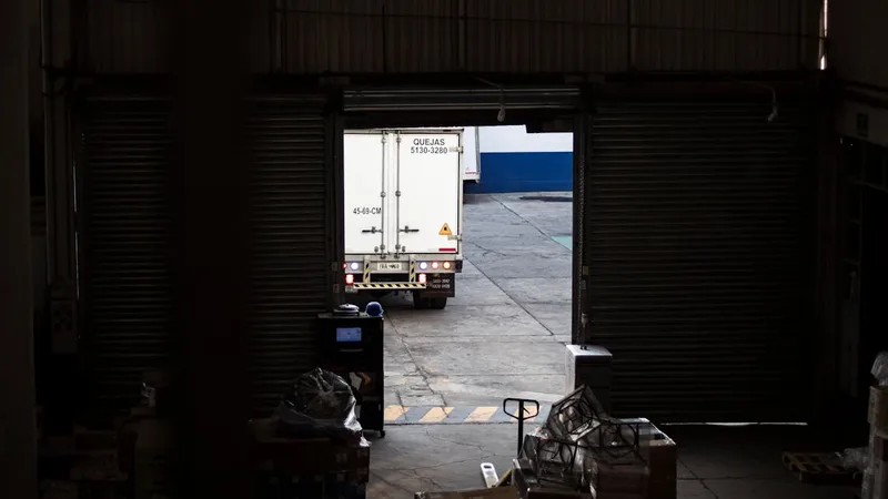 Camión de carga saliendo de bodega logística para recolección de mercancía en Colombia